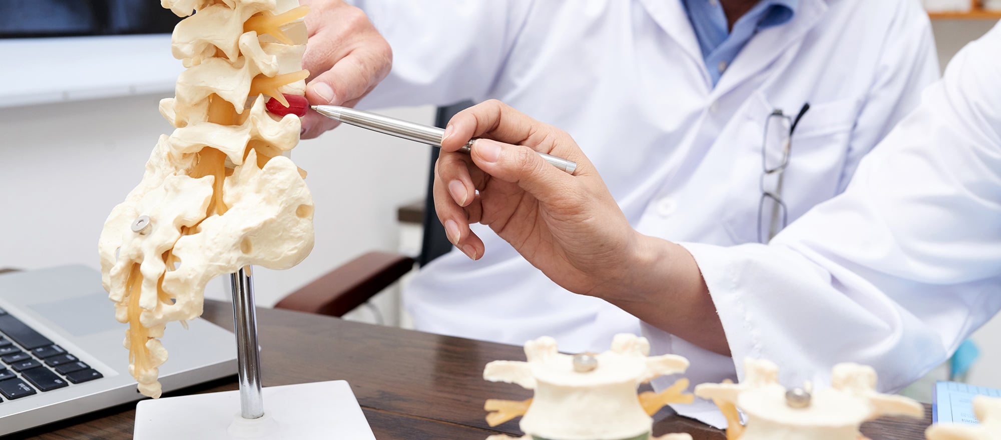 Physician using a spine model to explain a regenerative treatment plan at Pain Doctors Medical Perth Amboy