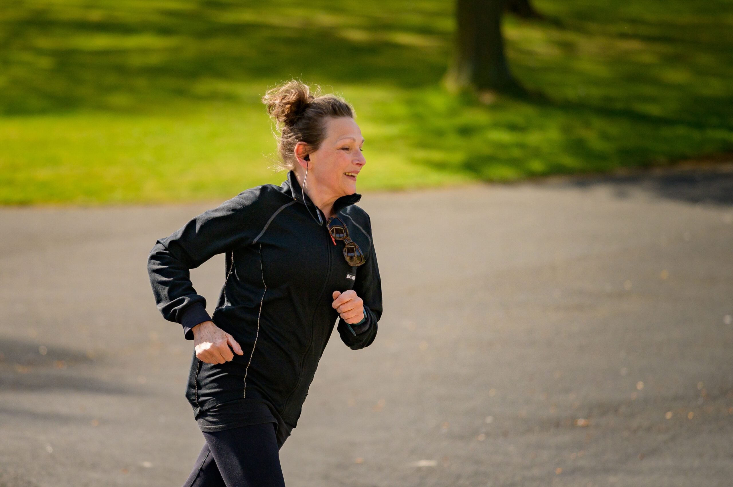 Woman running in a park after regenerative pain treatment