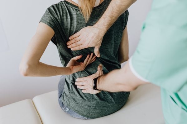 Clinician examining a patient's lower back to identify the true source of pain at Pain Doctors Medical