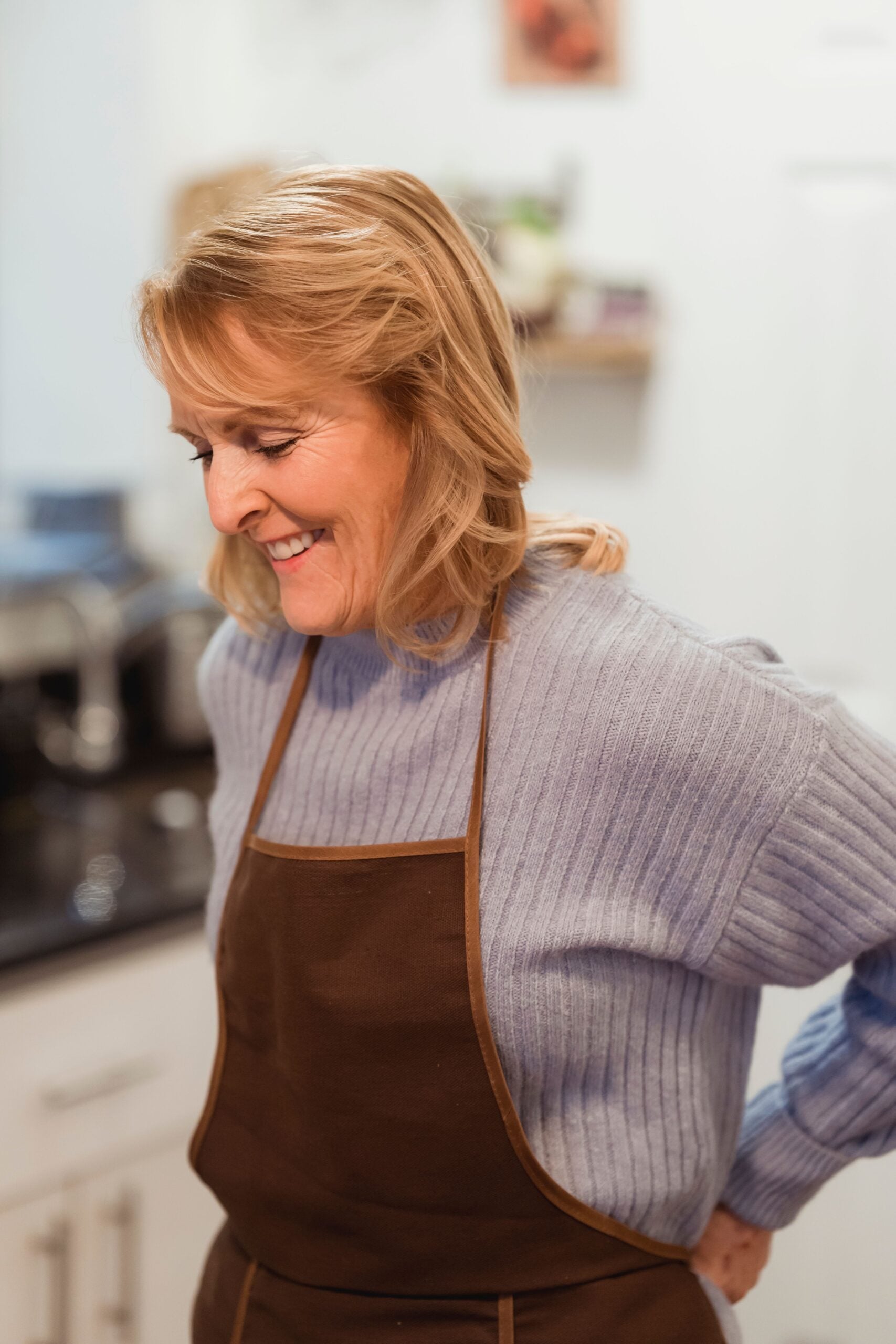 Woman cooking comfortably in her kitchen after regenerative treatment at Pain Doctors Medical