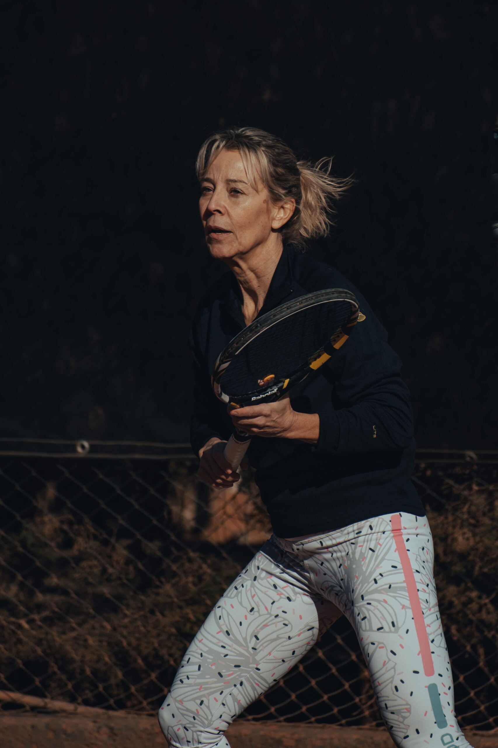 Woman playing tennis after returning to the sport following pain treatment